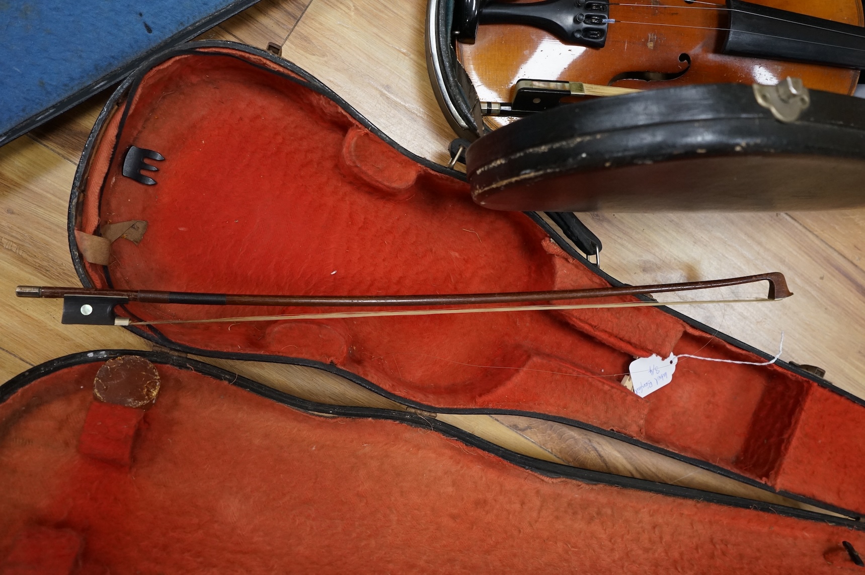 Five cased 20th century violins, including; a German violin, two Czech violins, a three-quarter size violin with a label for Bienfait, and a Romanian quarter size violin, all in cases or the remains of cases.